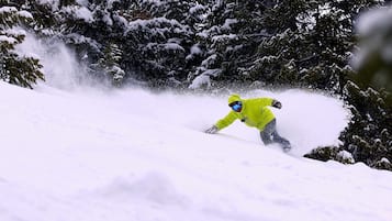 Una persona practica snowboard sobre una ladera nevada.