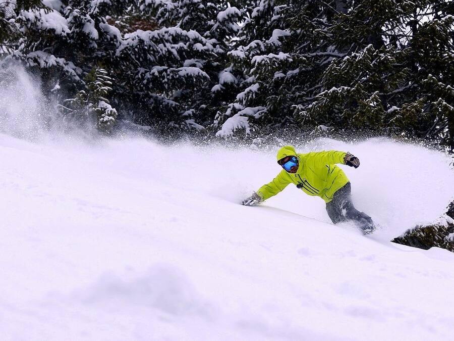 Una persona practica snowboard sobre una ladera nevada.