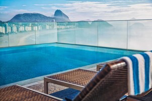 Una piscina al aire libre, sillones reclinables de piscina