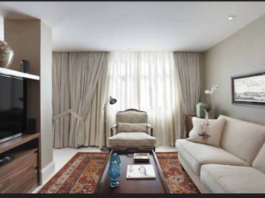 A living room with a television, a sofa, a chair, and a coffee table.