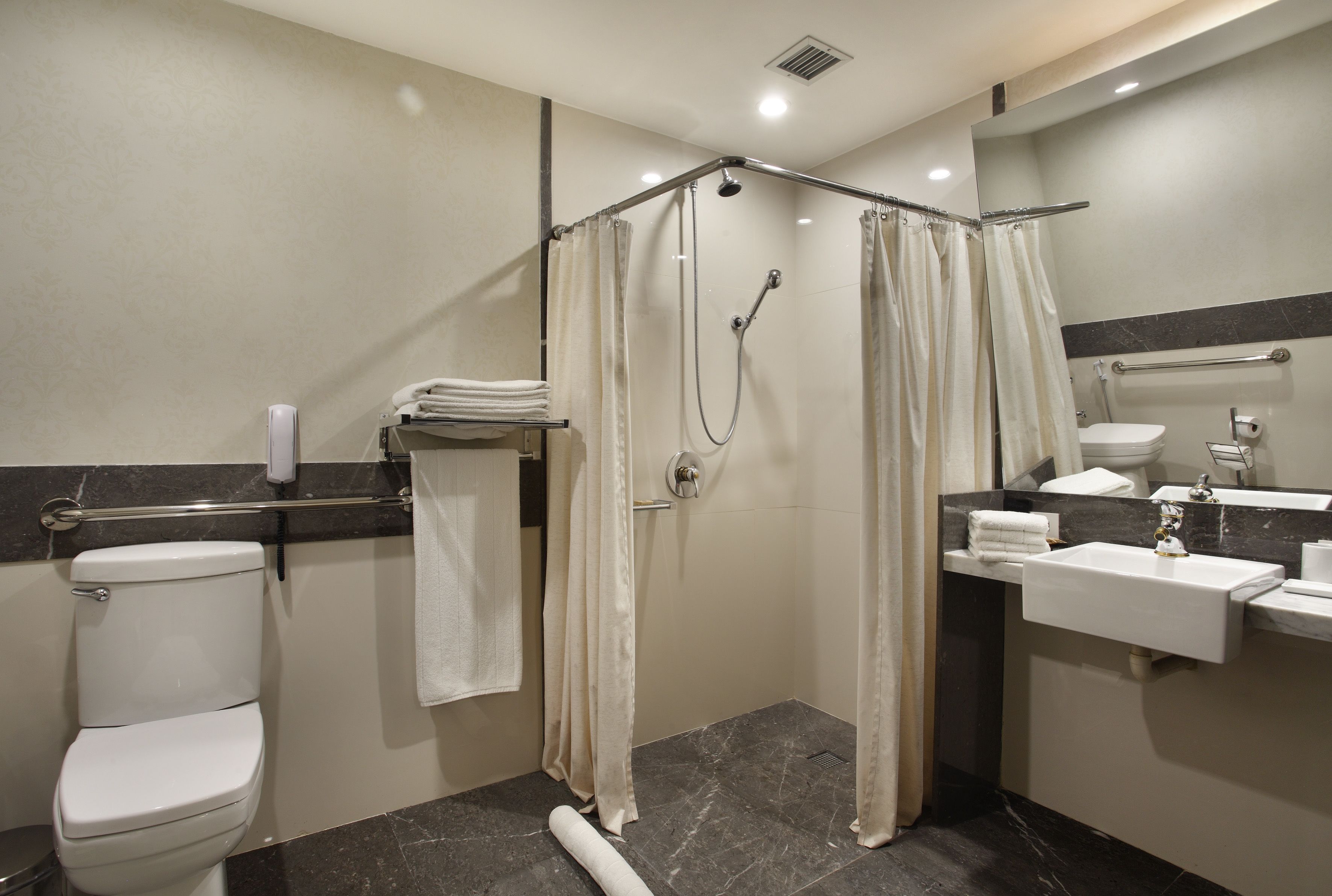 A modern bathroom with a shower, toilet, and sink.