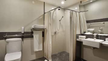 A modern bathroom with a shower, toilet, and sink.