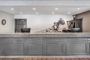 A reception desk with a marble countertop, a clock, and a wall mural depicting a person in a diving suit.