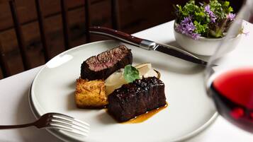 A plate with steak, vegetables, and sauce.