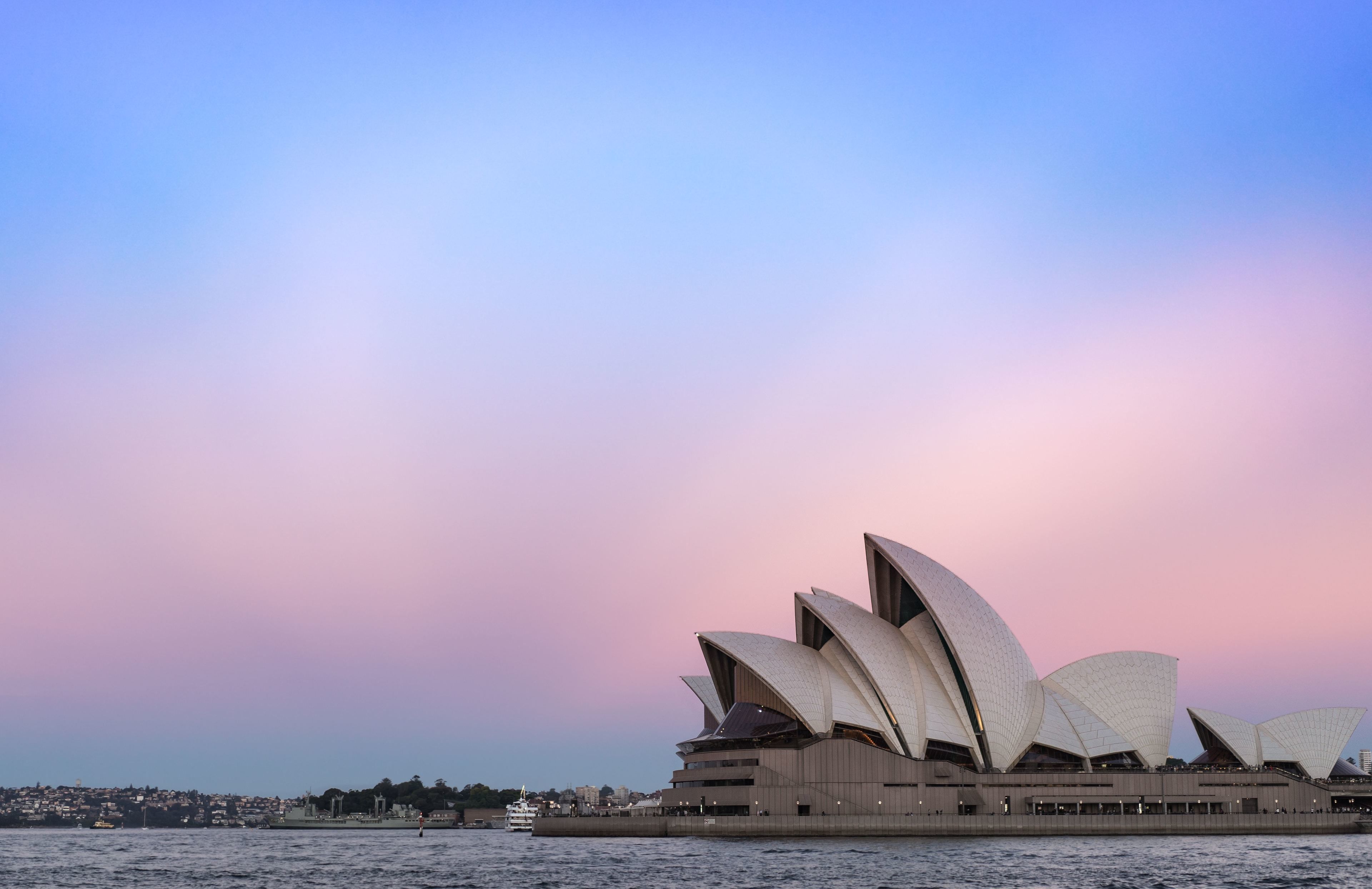 L’Opéra de Sydney, avec son architecture distinctive rappelant une voile, est situé au bord de l’eau.