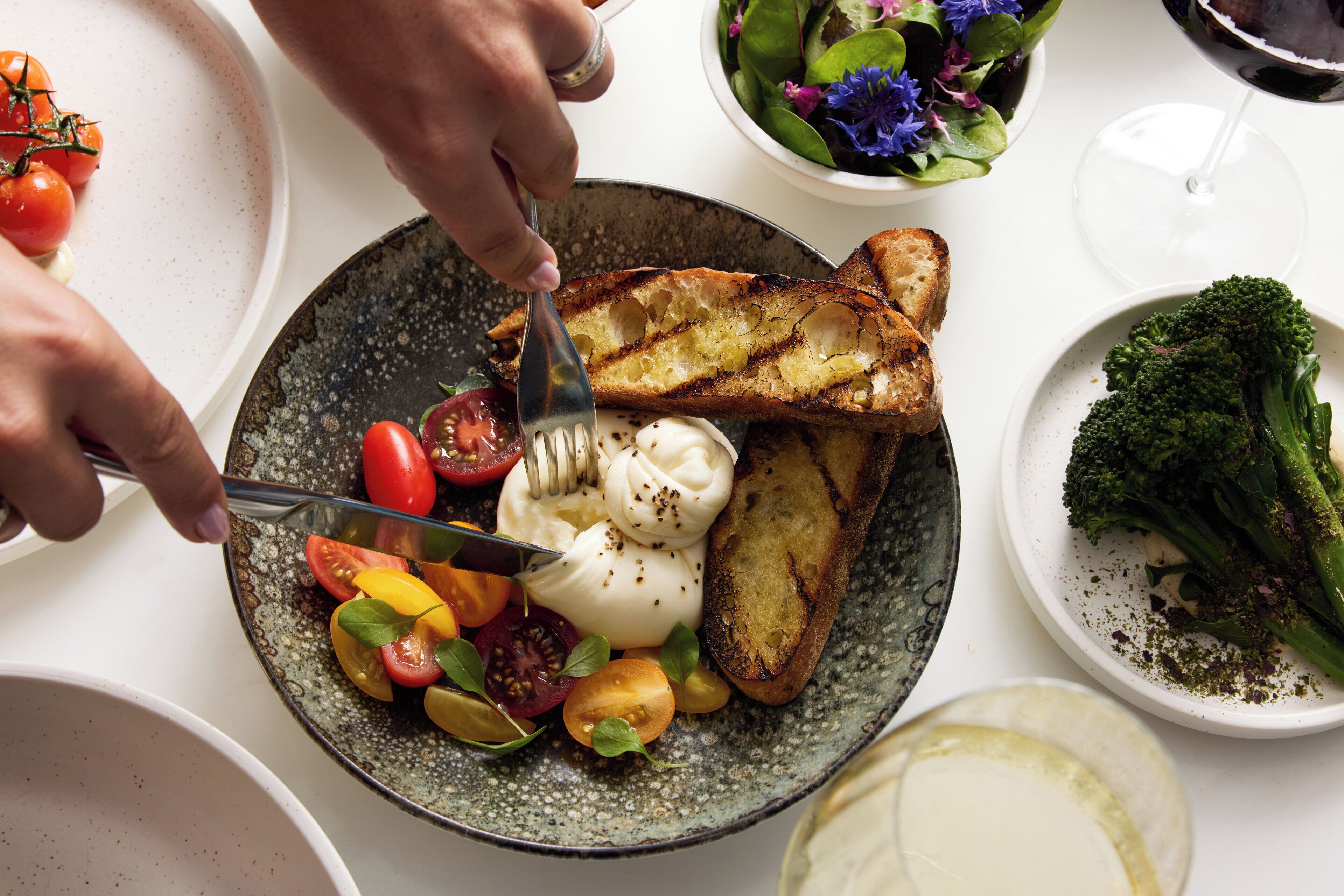 A plate with grilled toast, tomatoes, and a dollop of cream.