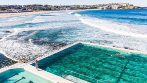 A pool with clear blue water, a beach, and a cityscape in the background. - InterContinental Sydney by IHG (Sydney)