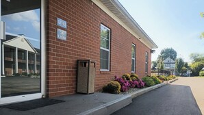 A brick building with a sign indicating an office on the ground floor. - Bourbon Capital Inn (Bardstown)