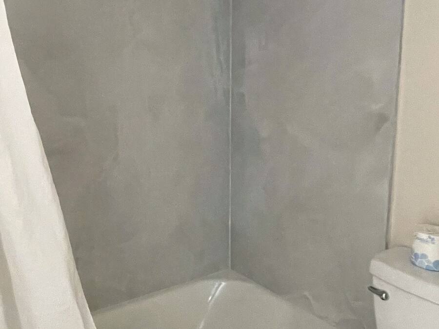 Un baño con bañera, inodoro y cortina de ducha.