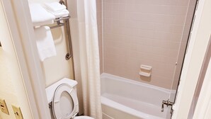 A bathroom with a toilet, a shower with a glass door, and a bathtub. - Simple Rewards Inn (Hilton Head Island)