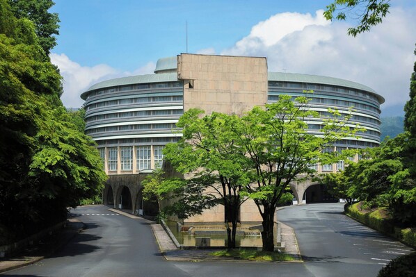 Stunning circular building with a central dome, surrounded by lush greenery and multiple levels with visible windows.