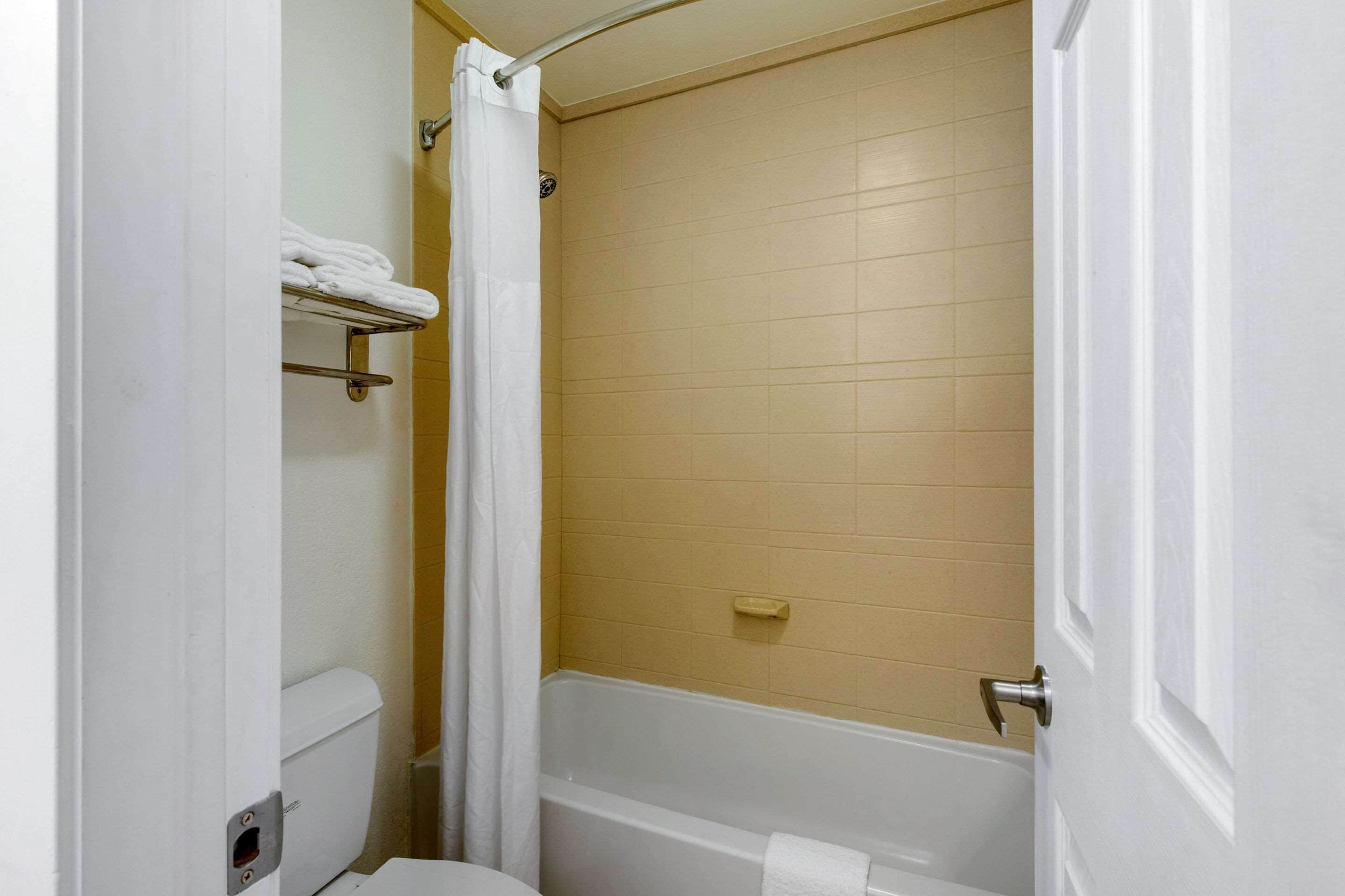 A bathroom with a bathtub, toilet, and towel rack.