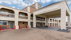 A multi-story hotel with a central atrium, balconies, and a clock tower. - Quality Inn Clute Freeport (Clute)