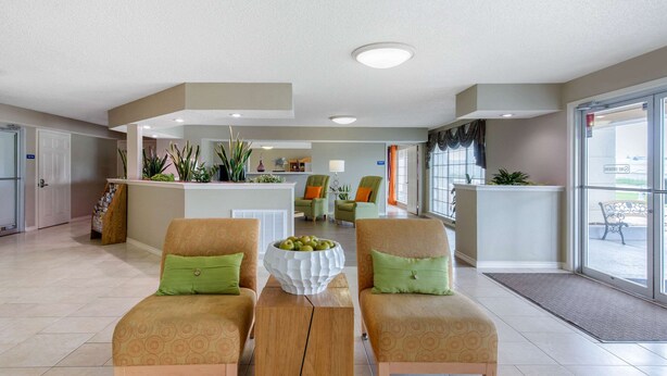 A hotel lobby with two armchairs, a coffee table, and a reception desk. - Quality Inn Clute Freeport (Clute)