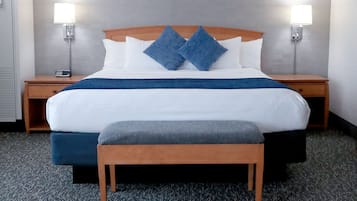 Camera d'albergo con un letto grande, due comodini, una panca e due lampade a parete.