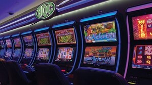 A row of slot machines with various game themes, including 'Triple Fortune Dragon' and 'Nefertiti'.