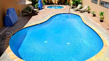 Alberca al aire libre, sombrillas en la alberca y camastros