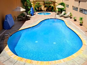 Relax by the pool surrounded by a tiled deck and lush greenery.
