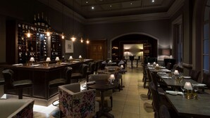 A bar area with a wine rack, multiple tables, and chairs, and a dining area with tables set for guests. - Bedford Lodge Hotel & Spa (Newmarket)