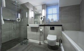 A modern bathroom with a glass shower enclosure, a toilet, a sink, and a bathtub.