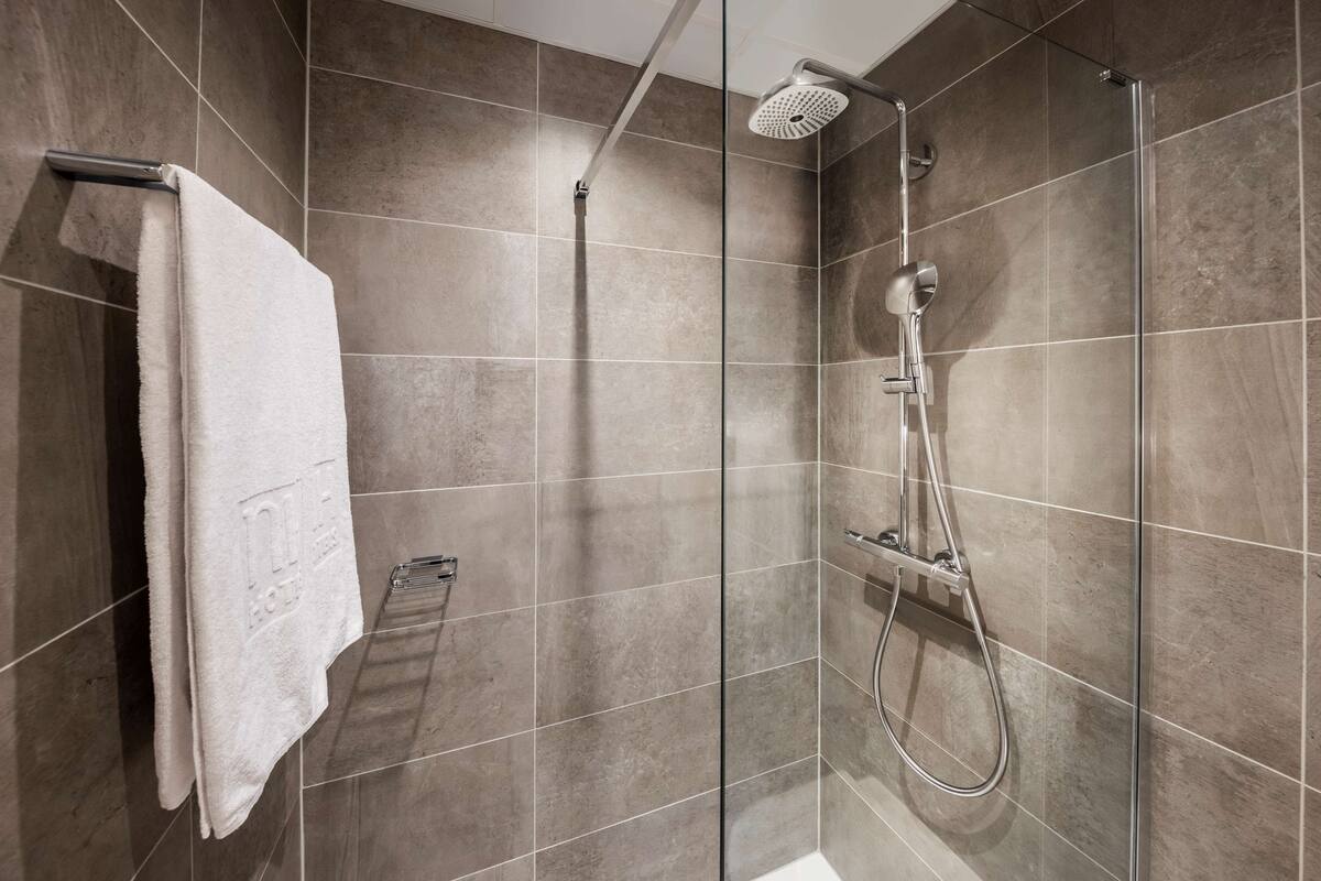junior suite | bathroom | deep-soaking bathtub, rainfall showerhead, eco-friendly toiletries