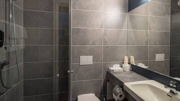 Un bagno moderno con doccia, WC e lavandino.