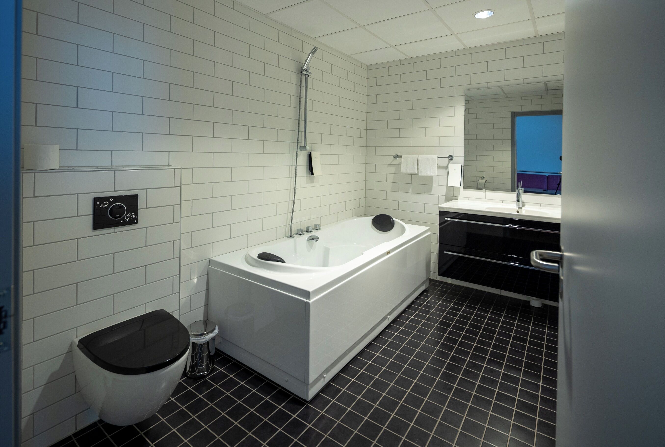 Ein modernes Badezimmer mit einer weißen Badewanne, einer Toilette und einer Dusche.