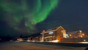 Ein Hotel im modernen Design, gelegen in einer verschneiten Gegend mit Blick auf das Nordlicht.