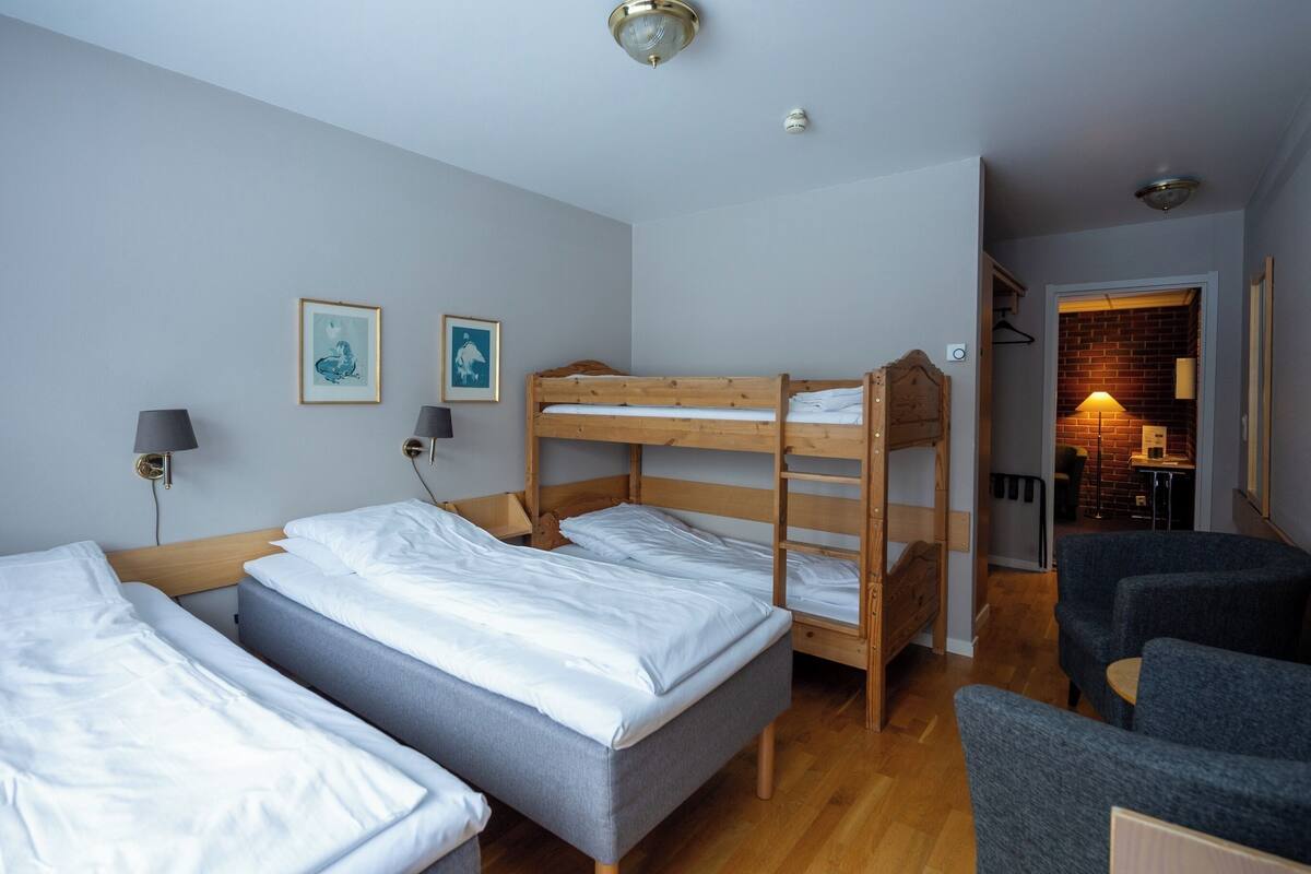 Ein Zimmer mit Etagenbetten, einem Schreibtisch und zwei Stühlen.