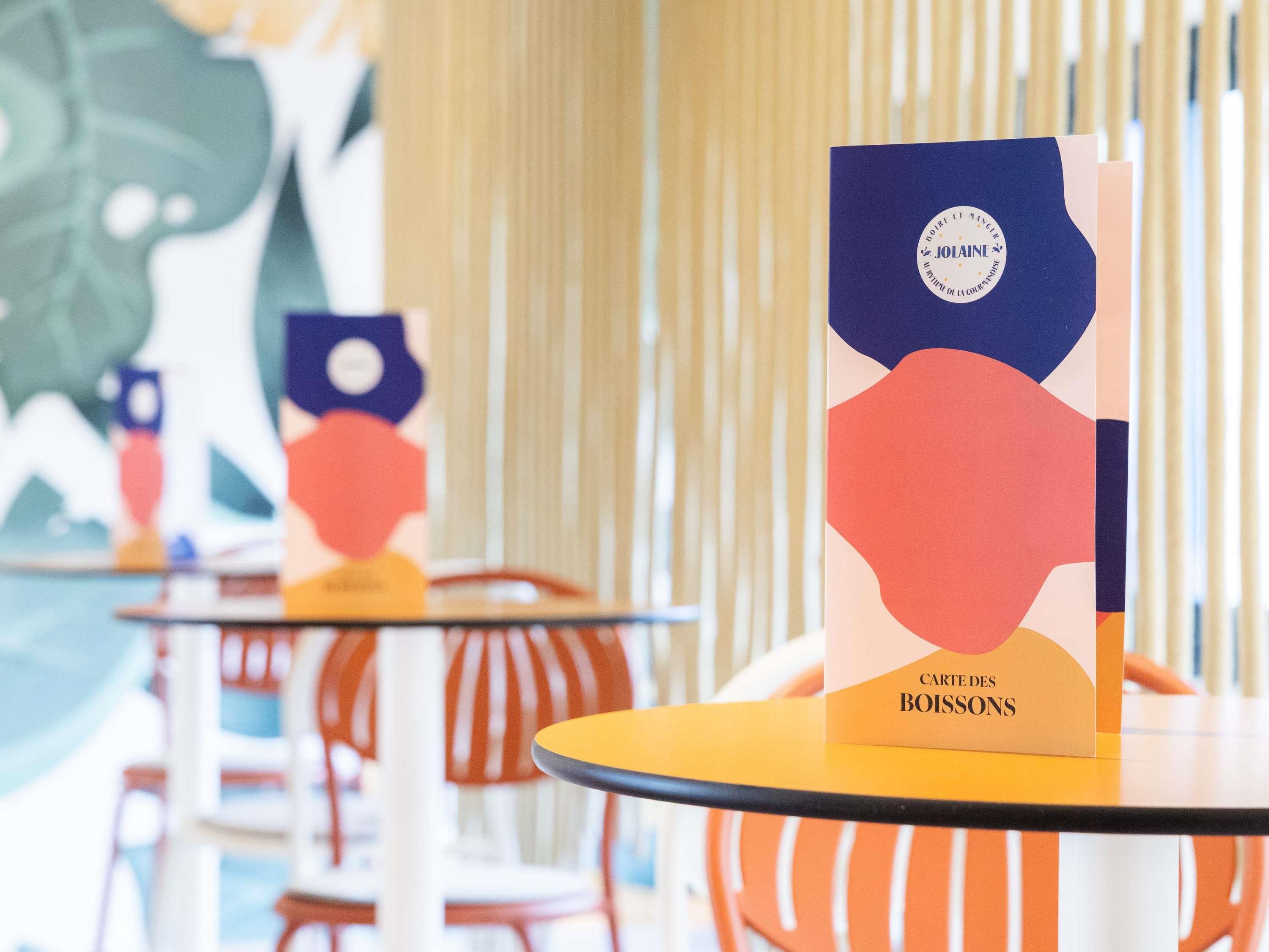 Una mesa con una tarjeta de menú que dice 'CARTE DES BOISSONS' en un restaurante.