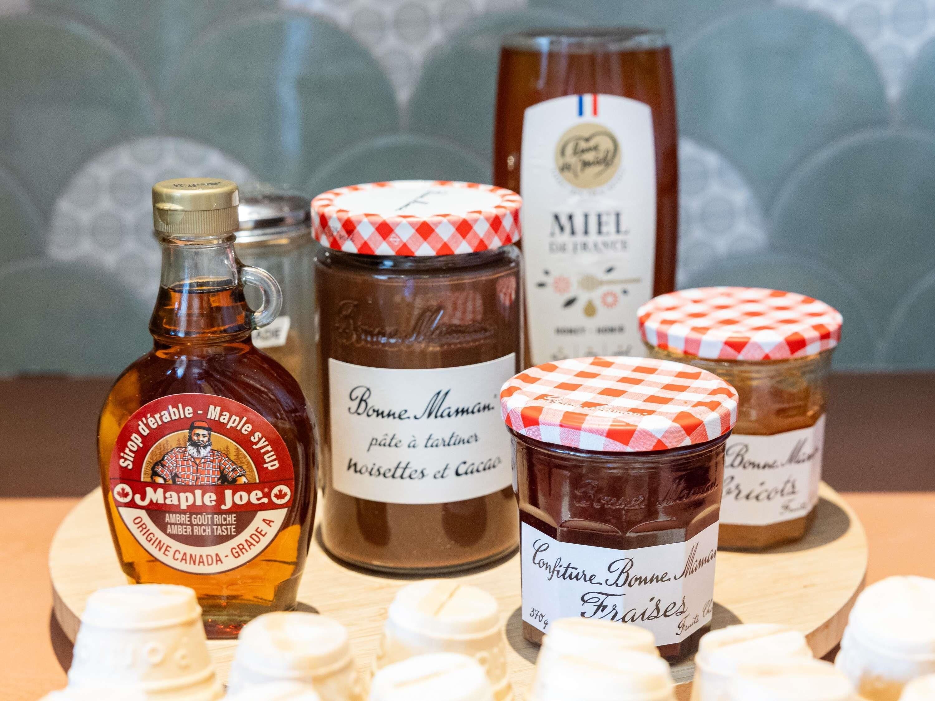 Verschiedene Lebensmittel, darunter Ahornsirup, Schokolade und Gebäck, auf einer Holzbrett.