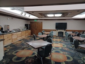 A conference room with a wooden counter, a fireplace, and a large flat-screen TV.