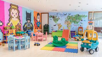 Children can play and learn in this colorful room featuring a large wall mural and various toys.