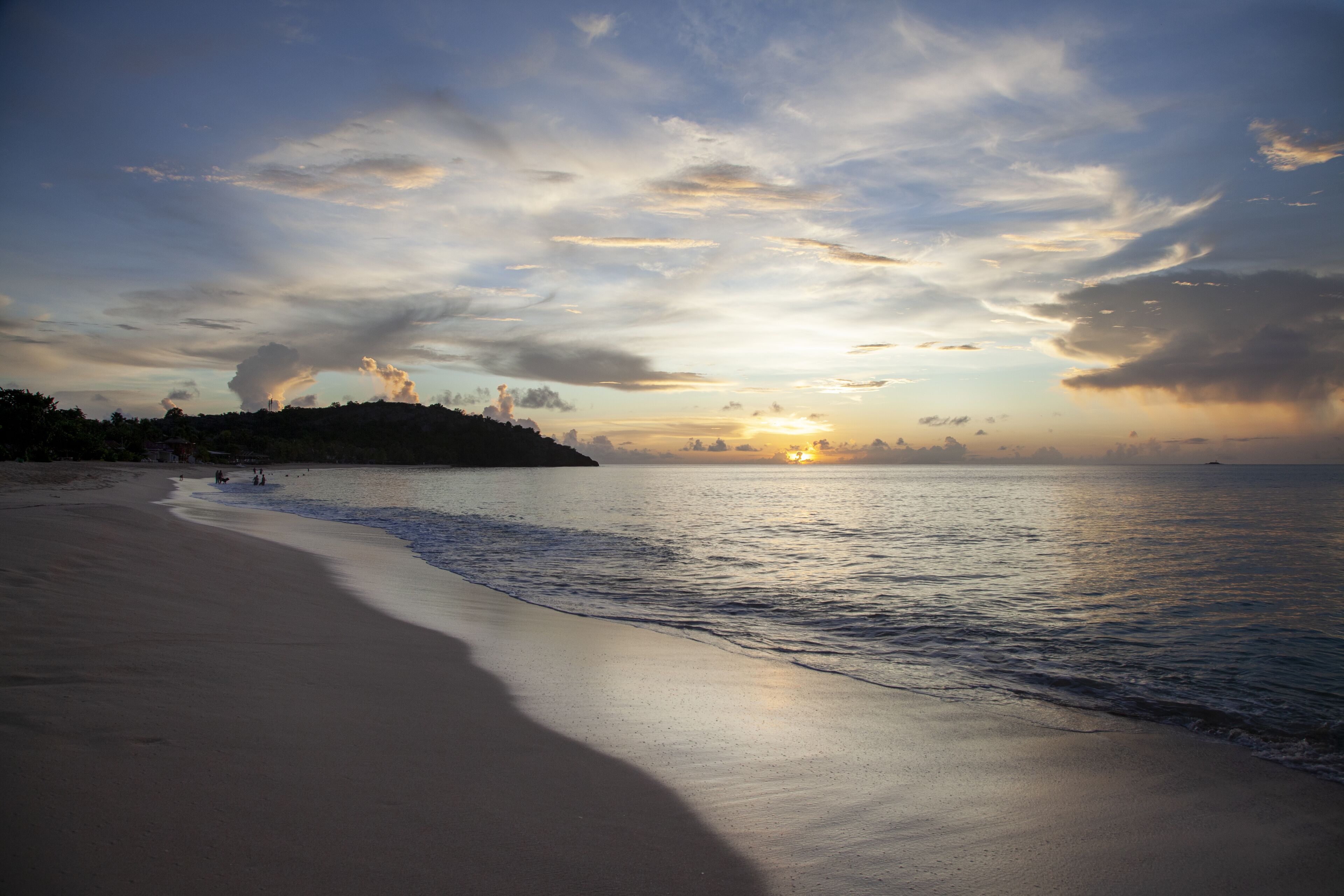 A beach with a wide sandy shore and gentle waves.