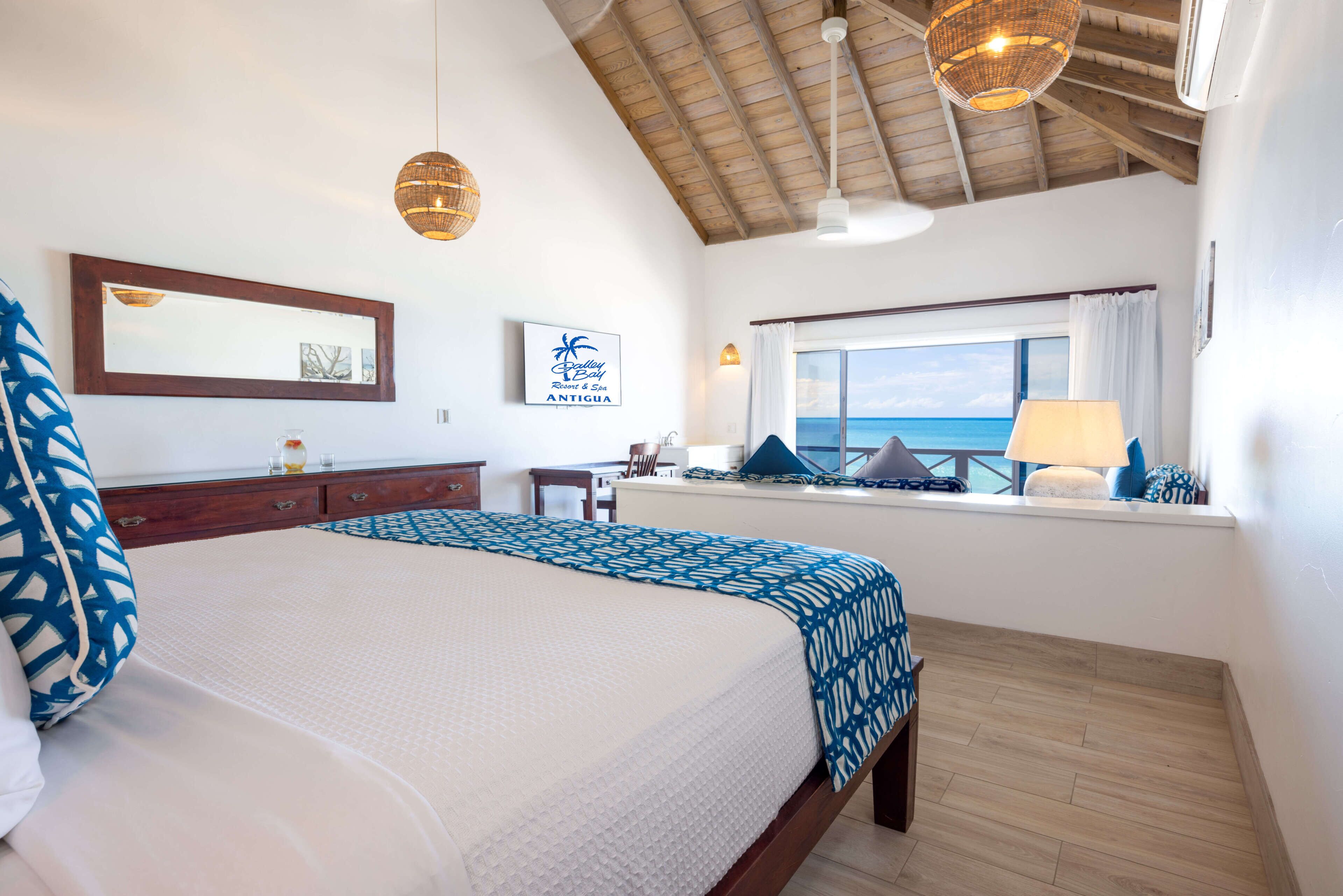 Une chambre à coucher avec un lit, une commode, une fenêtre donnant sur un beau paysage et un ventilateur de plafond.
