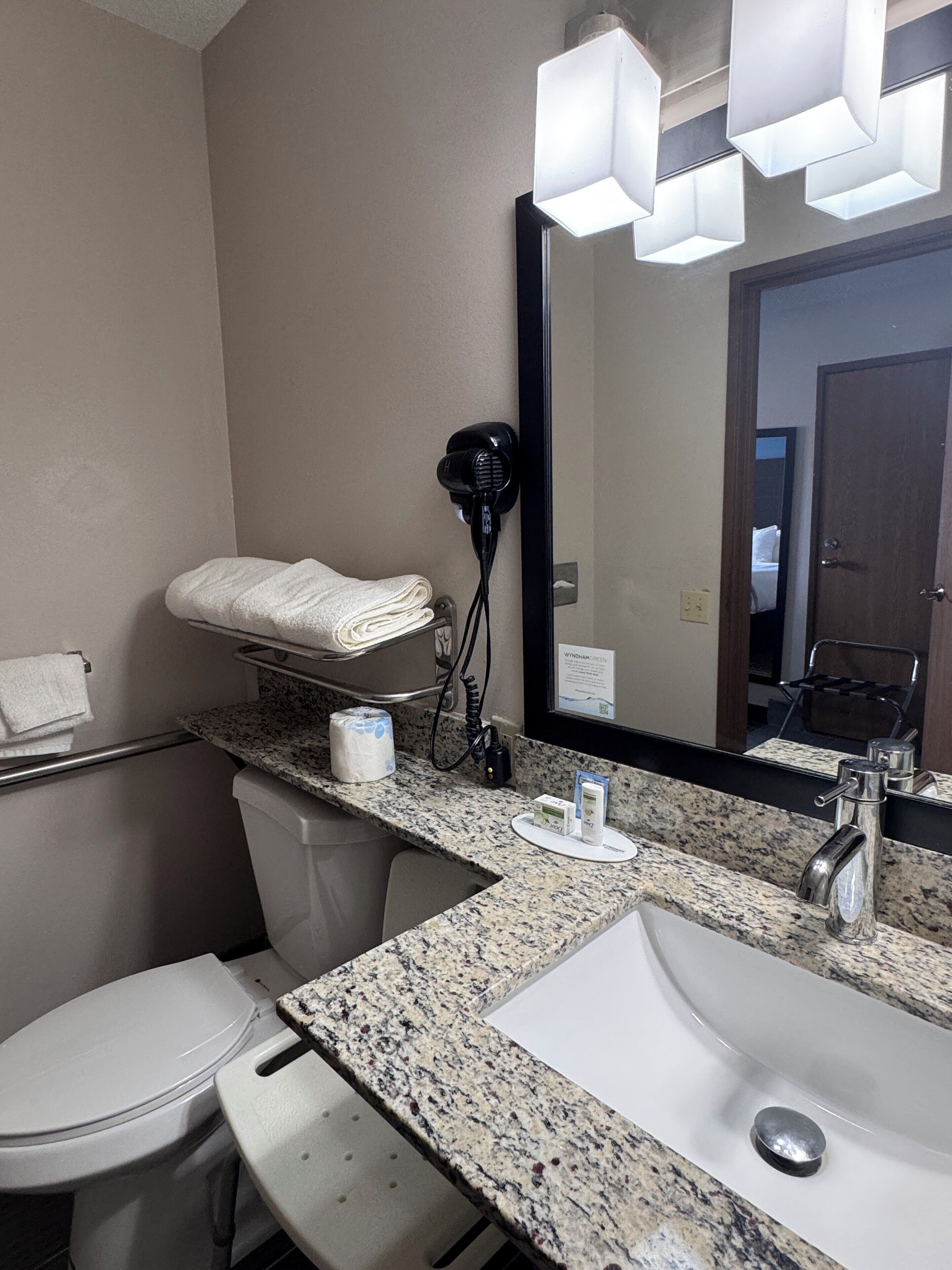 A bathroom with a sink, mirror, towel rack, and hair dryer.