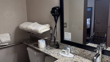 A bathroom with a sink, mirror, towel rack, and hair dryer.