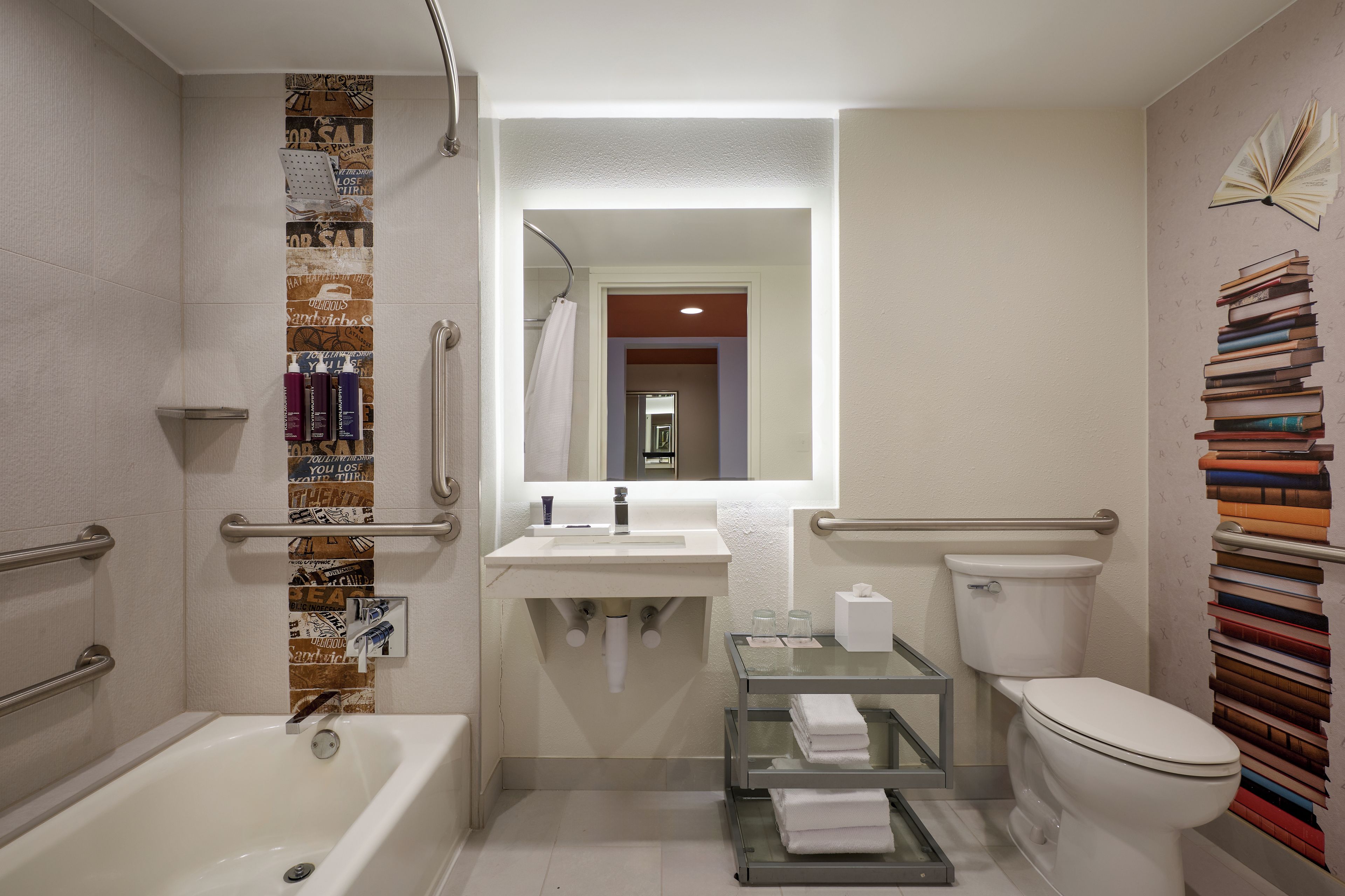 Un baño con bañera, inodoro, lavabo y un perchero para toallas.