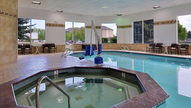 An indoor swimming pool with a hot tub, seating area, and large windows. - Hampton Inn Idaho Falls/Airport (Idaho Falls)