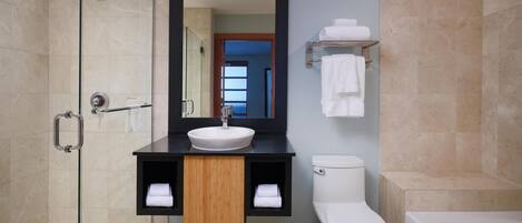 Une salle de bain moderne avec une douche à parois de verre, un lavabo blanc et une baignoire.