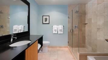 A modern bathroom with a black sink, white toilet, and a glass-enclosed shower.