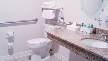 A bathroom with a toilet, a sink, a mirror, and a towel rack.
