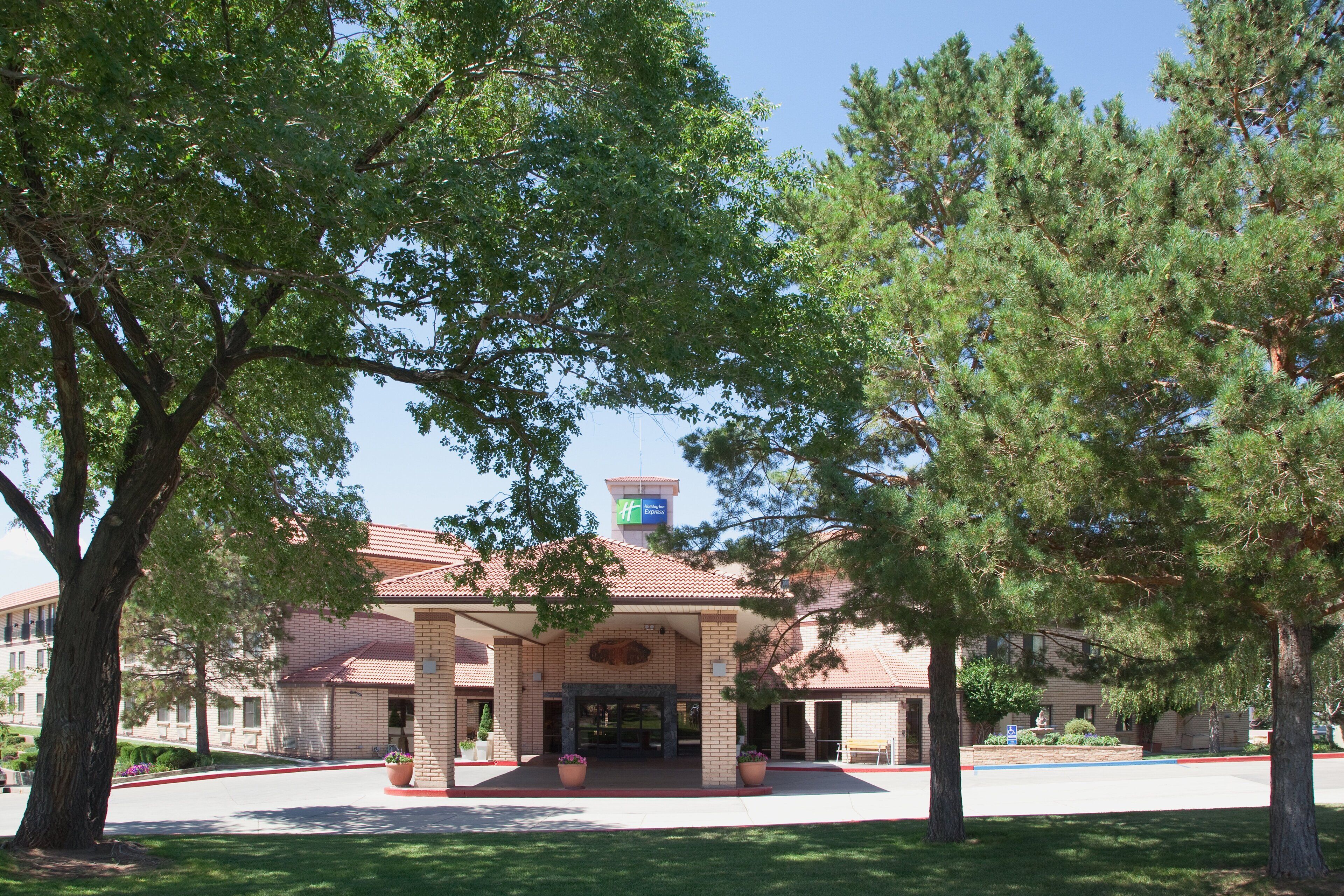 A brick building with a red-tiled roof, a large entrance, and a Holiday Inn Express sign.