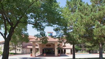 A brick building with a red-tiled roof, a large entrance, and a Holiday Inn Express sign.