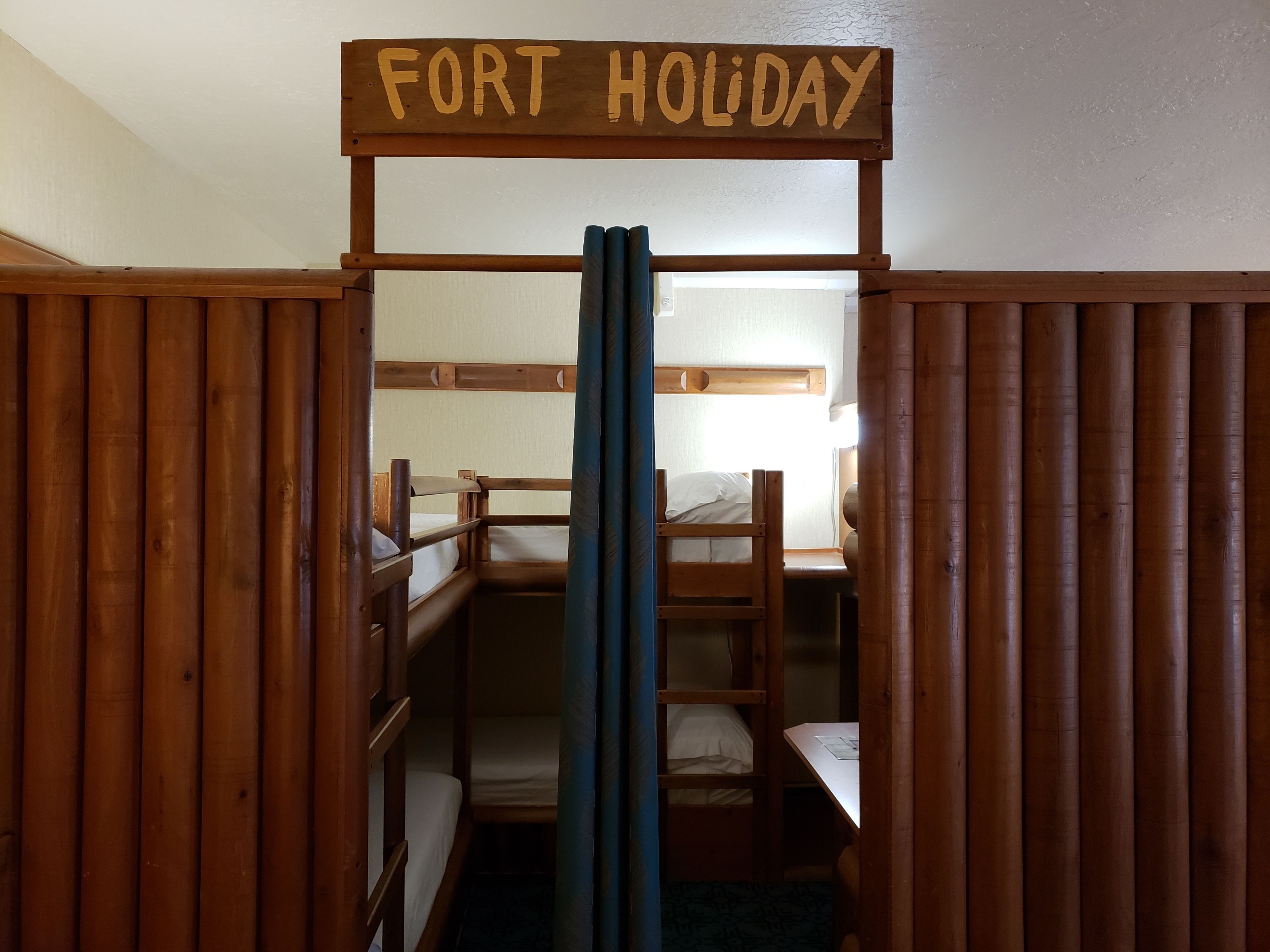 A bunk bed room with a sign reading "FORT HOLIDAY".