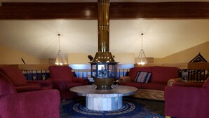 A cozy lounge area with a central round table, red sofas, and a patterned carpet. - Holiday Inn Express Mesa Verde-Cortez by IHG (Cortez)