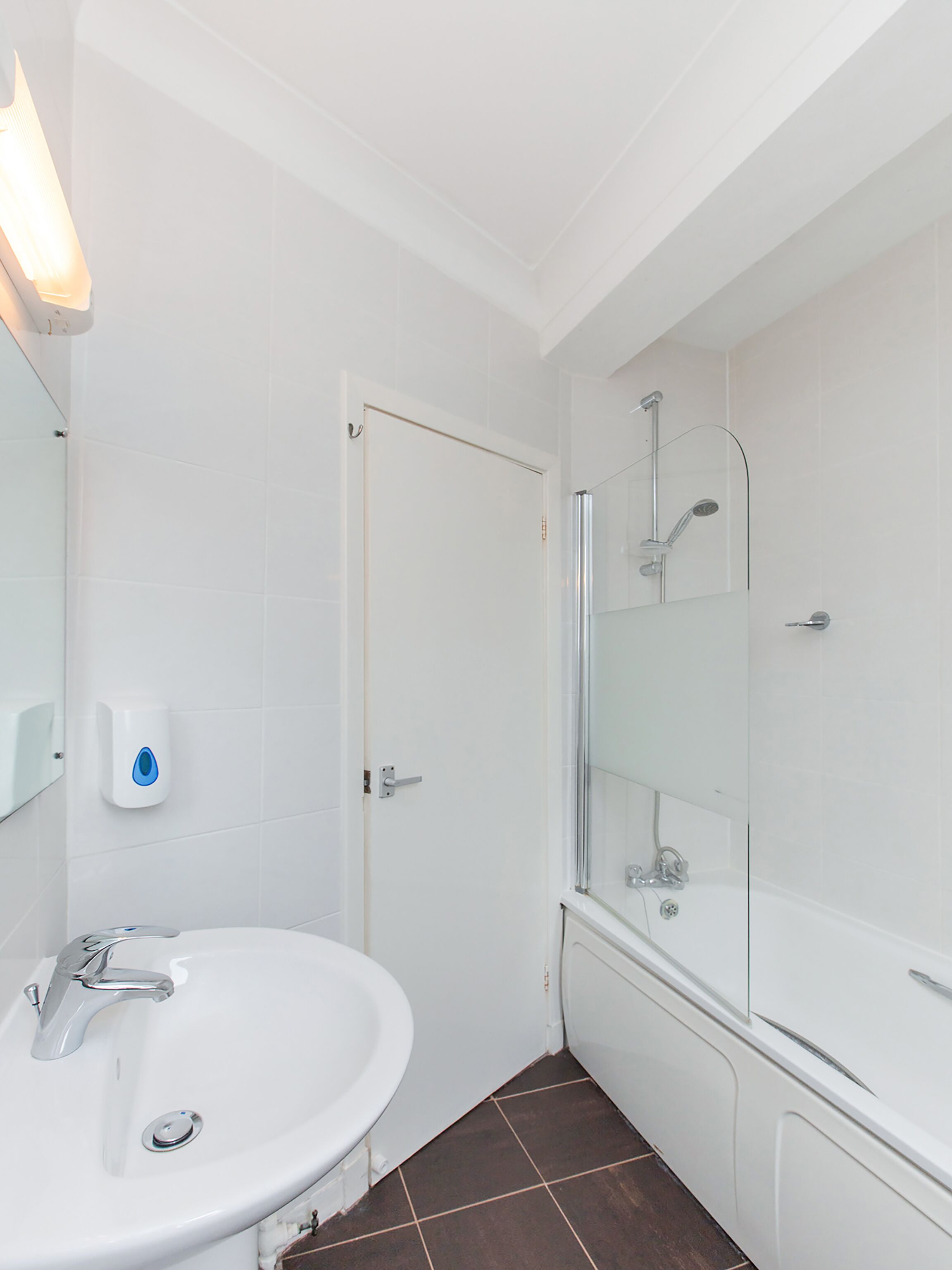 A bathroom with a white sink, a glass shower enclosure, and a white toilet.