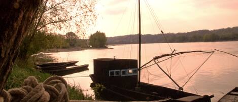 A dock with boats, a rope, and a building with a window.