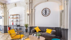 Un salon moderne comprenant un canapé, un fauteuil, une table basse et des objets décoratifs.