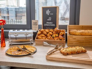 A bakery display with various baked goods, a toaster, and a sign indicating gluten-free options. - ibis Blois Centre Chateau (Blois)